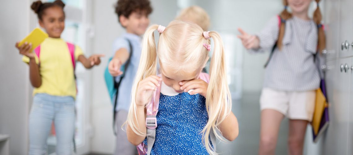 Little girl crying. Blonde-haired little girl crying while feeling offended by classmates
